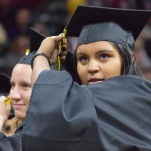 Student adjusting the tassel on her graduation cap